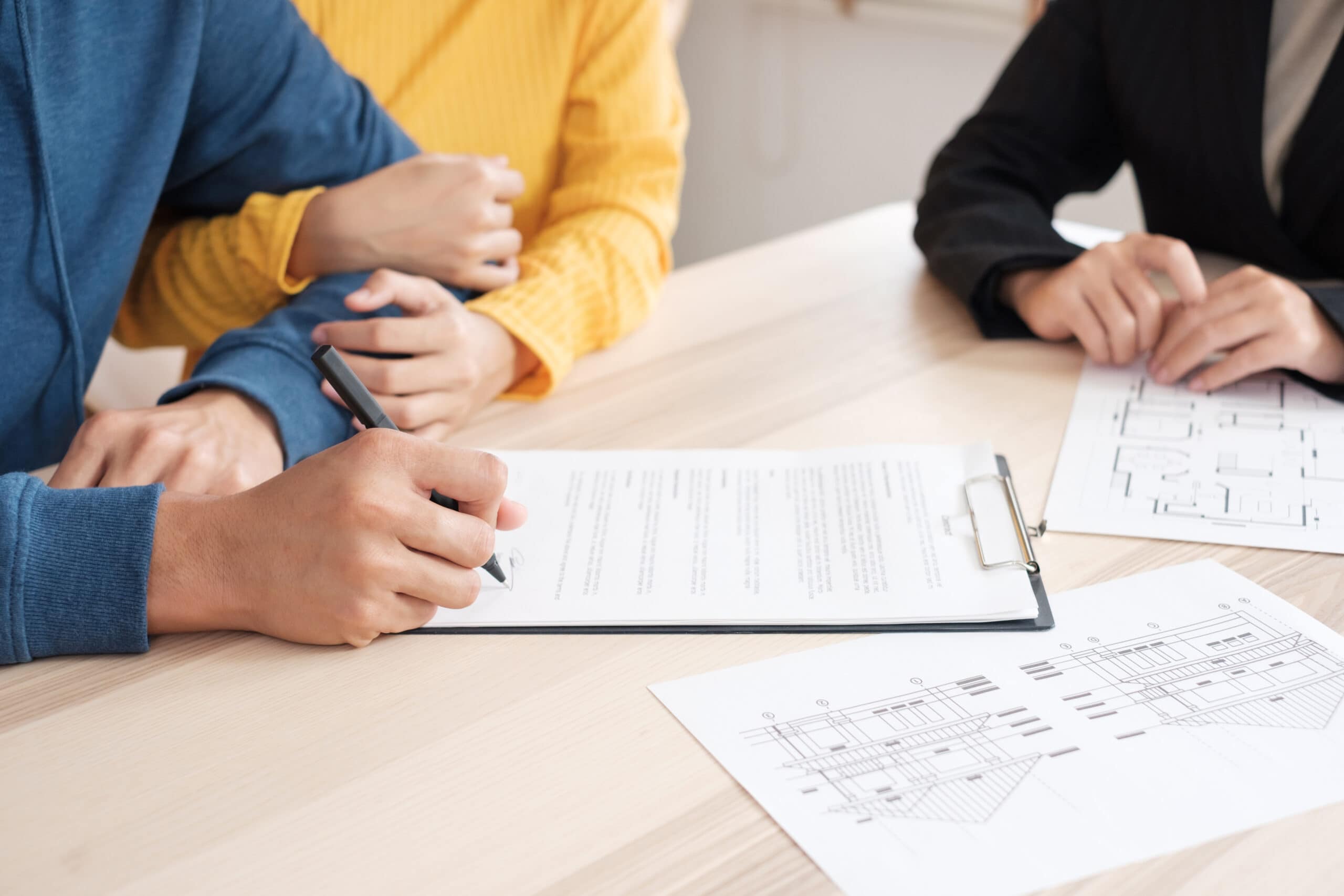 Stock image of a couple signing paperwork - find Shared Ownership homes on Share to Buy!