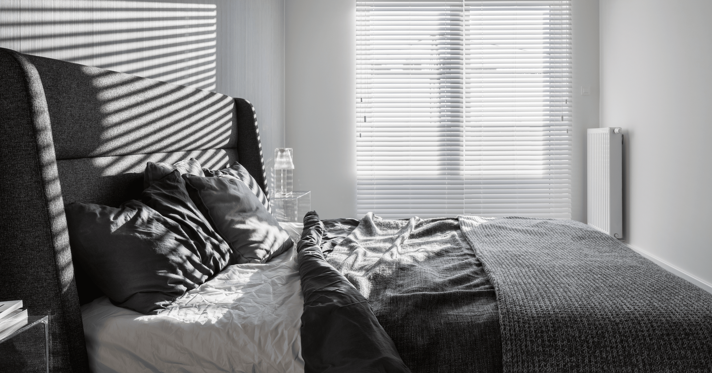 A stock image of a bedroom with window shutters - start your property search on Share to Buy!