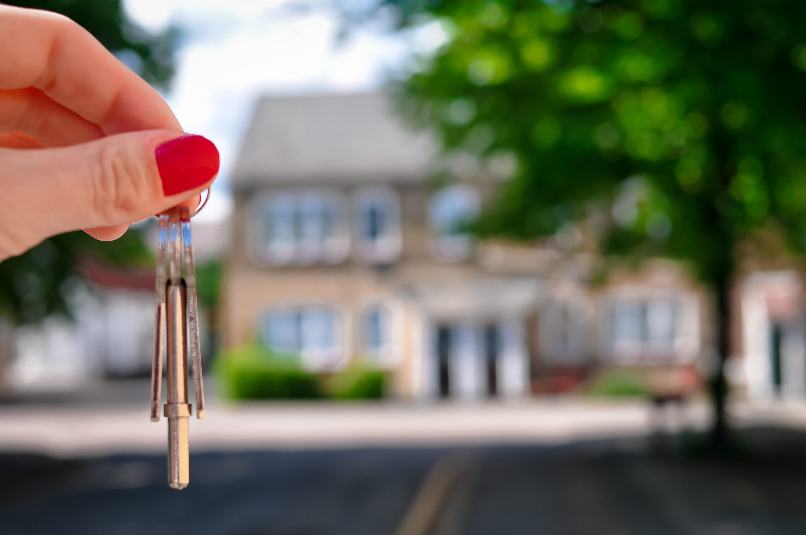 Woman's hand holding keys to her new home. Start your property journey on Share to Buy!
