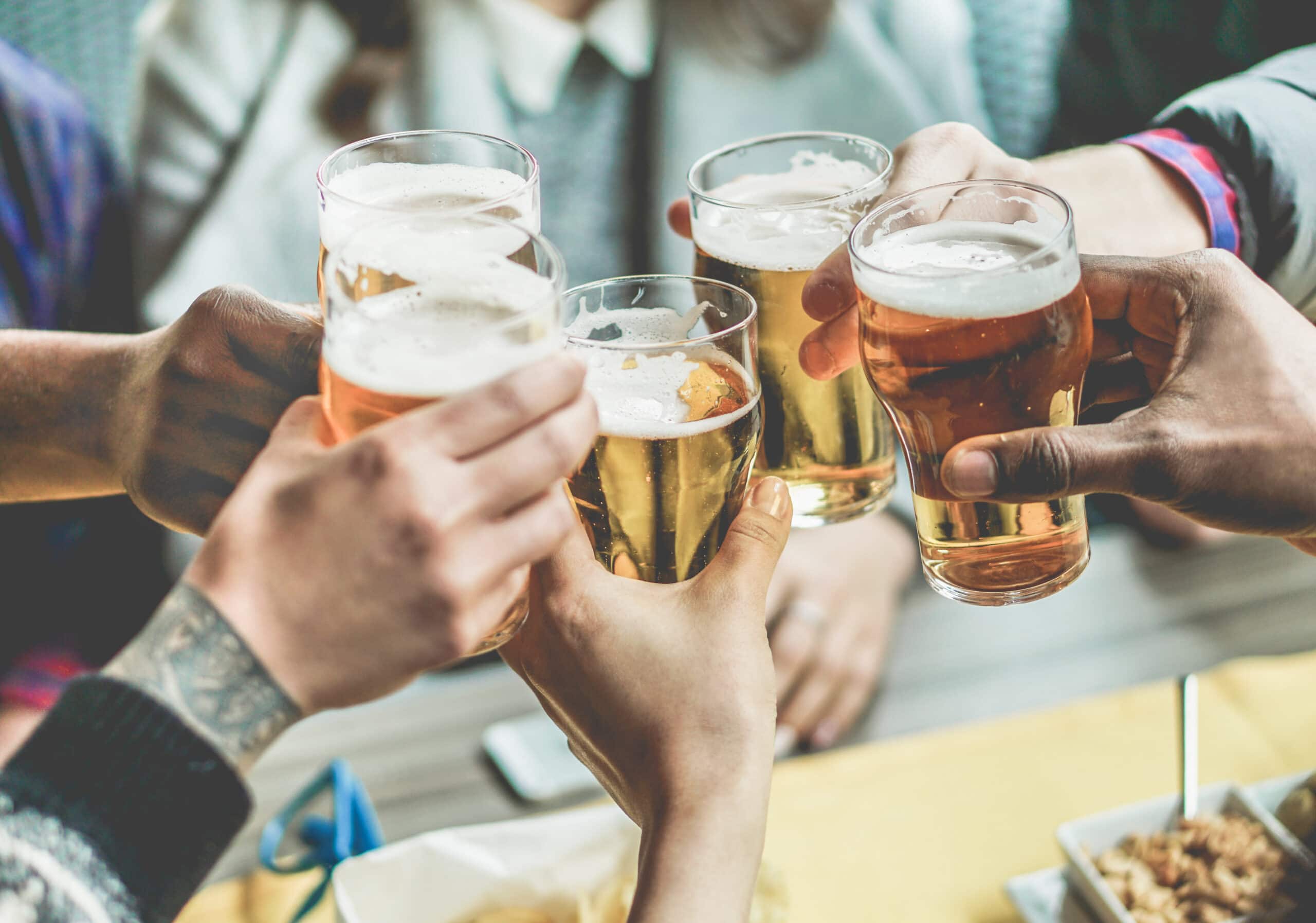 Stock image of a group of friends enjoying a beer - Start your property journey on Share to Buy!