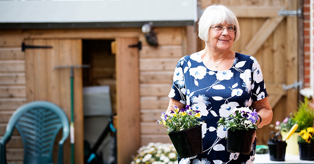 Stock image of an elderly women in her garden - Start your property journey on Share to Buy!
