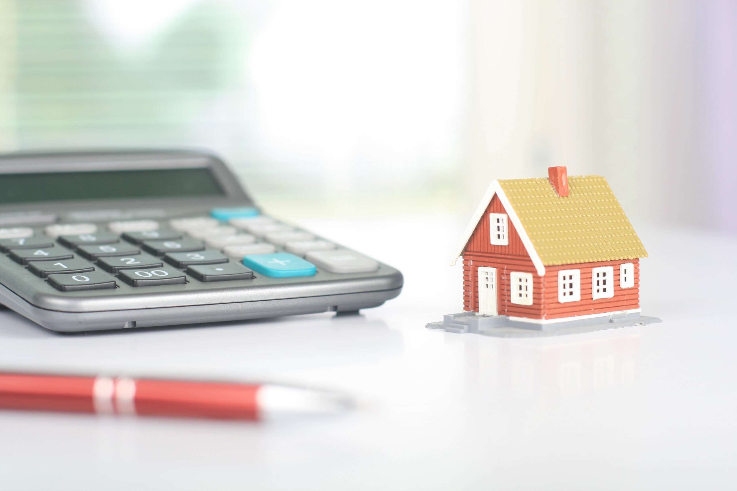 A stock image of a model house and calculator. Find a Shared Ownership mortgage with Censeo Financial - Share to Buy's broker partner!