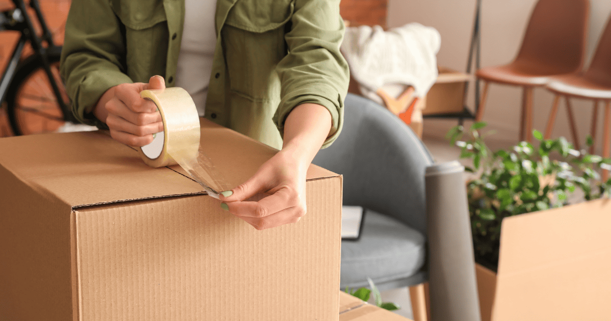 Image of a woman taping up a packing box. Start your property journey on Share to Buy!