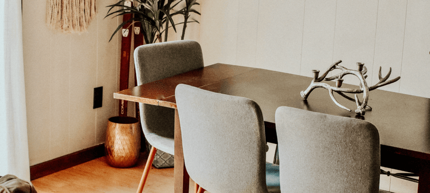 Dining room set up with grey chairs and a wooden table