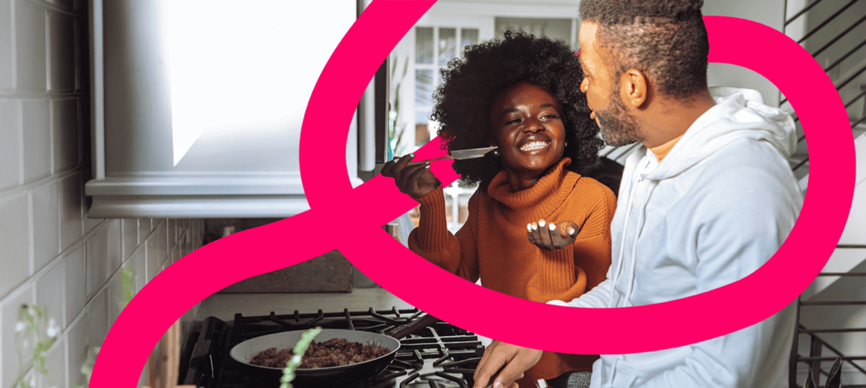 Young couple cook in their new home. Share to Buy's pink 'pathway' runs around them.