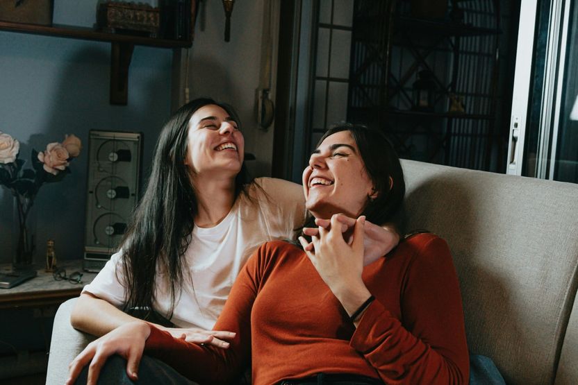 Image of women laughing together on a sofa