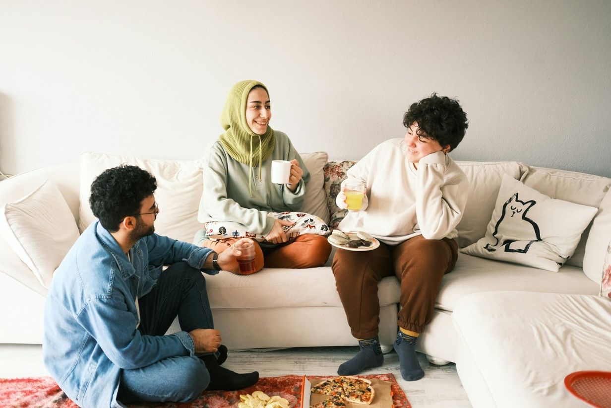 Friends laughing sat around a sofa