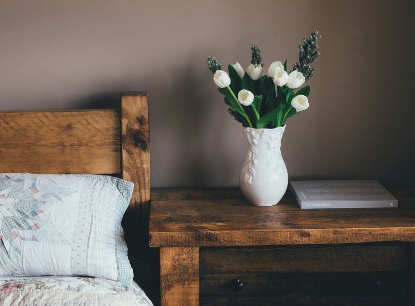 Wooden bedroom furniture, white flowers in vase