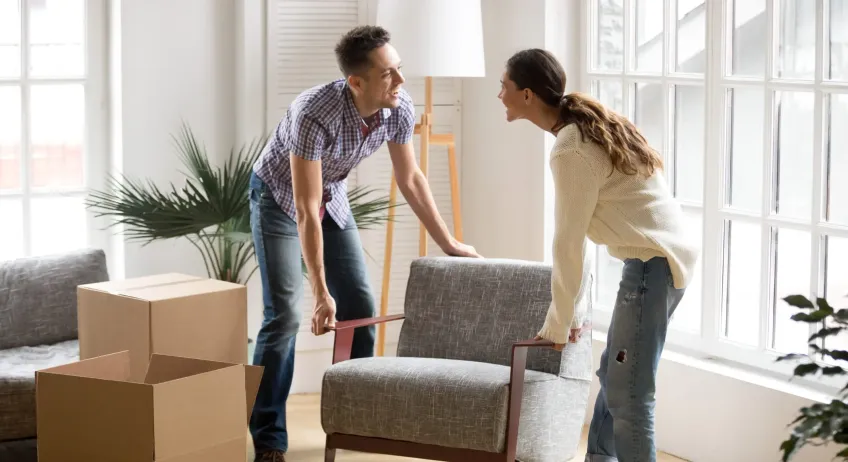 Couple moving furniture in a living room