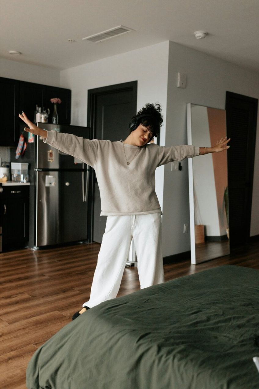 girl dancing with headphones in kitchen