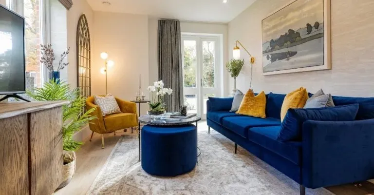 living room with royal blue sofa and mustard chair and other interior