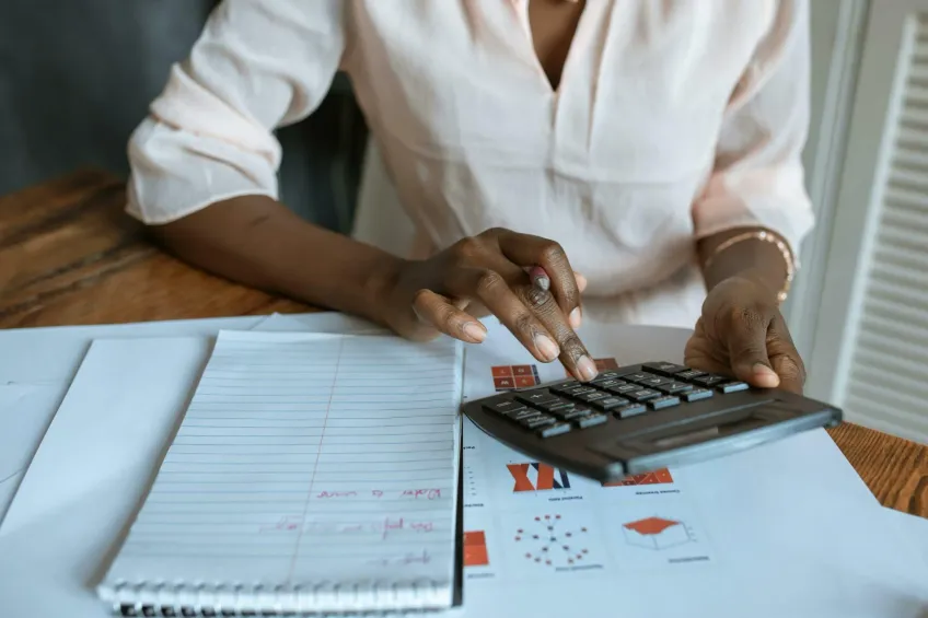 woman using calculator with notepad