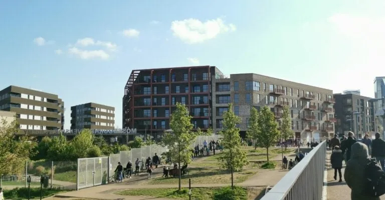 outdoor view of flats in the distance with lots of green spaces and people walking