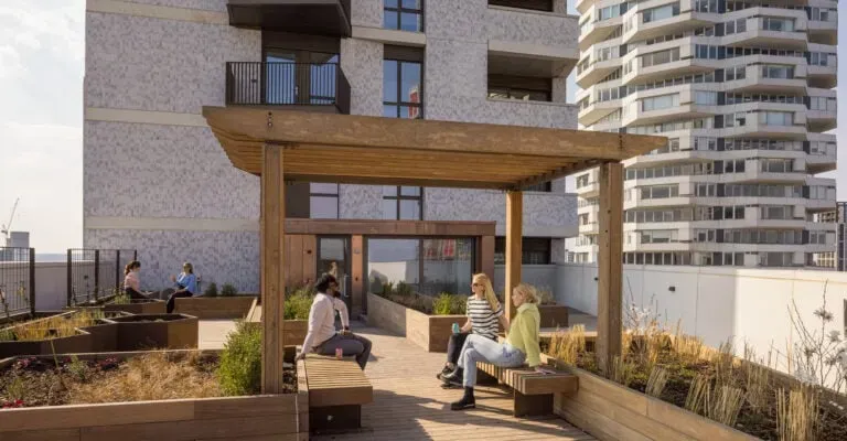 group of people sat outside on a terrace of a block of flats