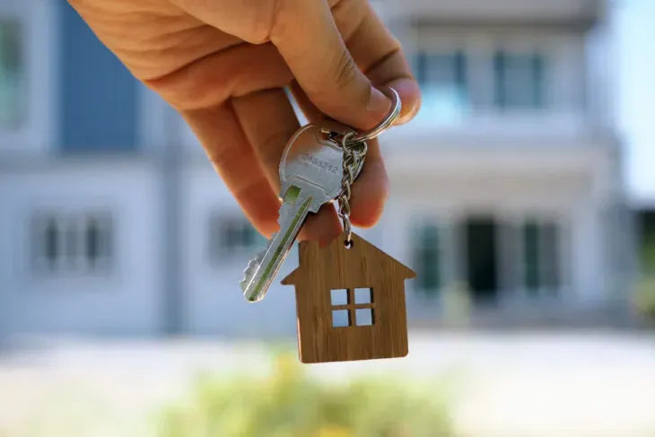 hand holding keys with house shaped keychain