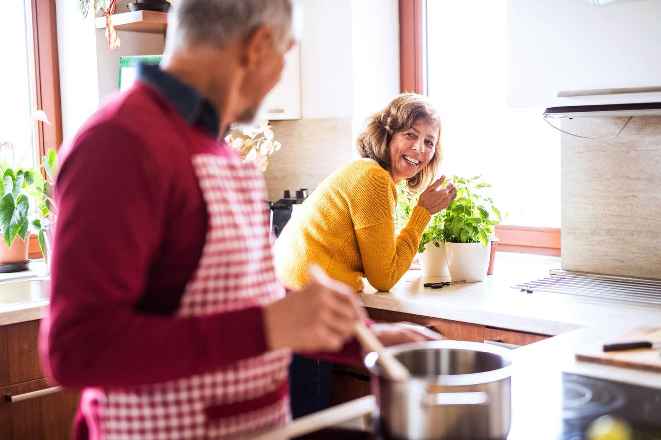 Happy couple at home cooking in their kitchen