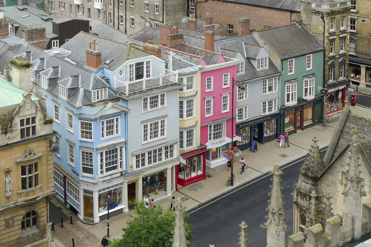 A row of historic buildings on Oxford's High Street, each painted in a unique pastel hue.