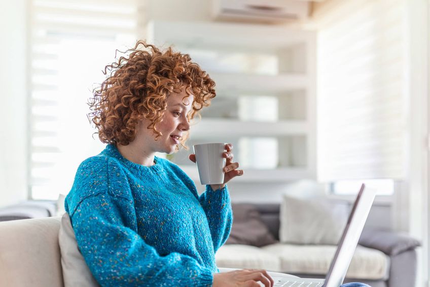 Woman using her laptop to search for her first home to buy