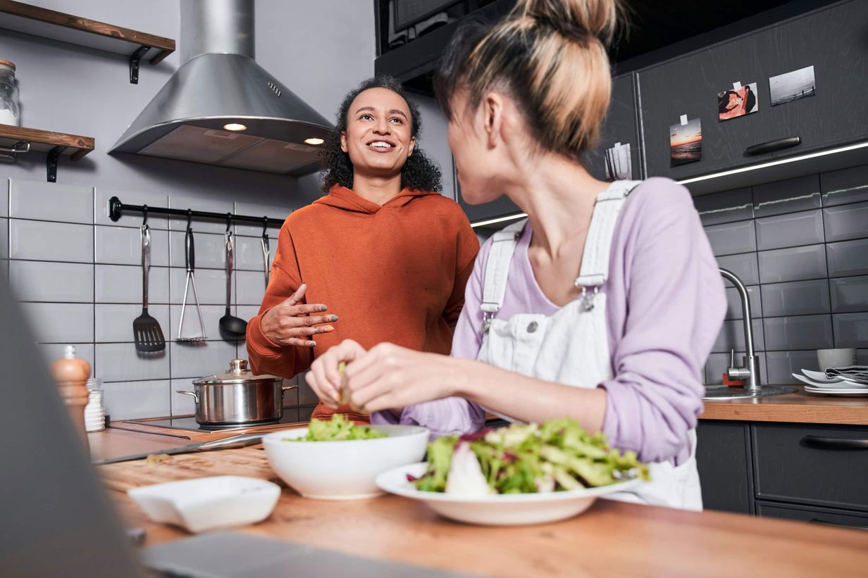 Two friends in the kitchen making lunch