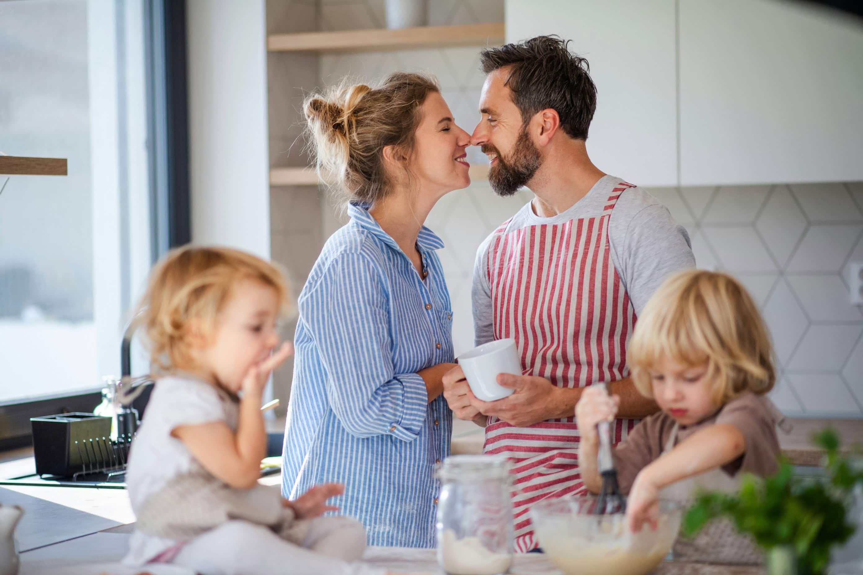 Young couple baking with their two children.