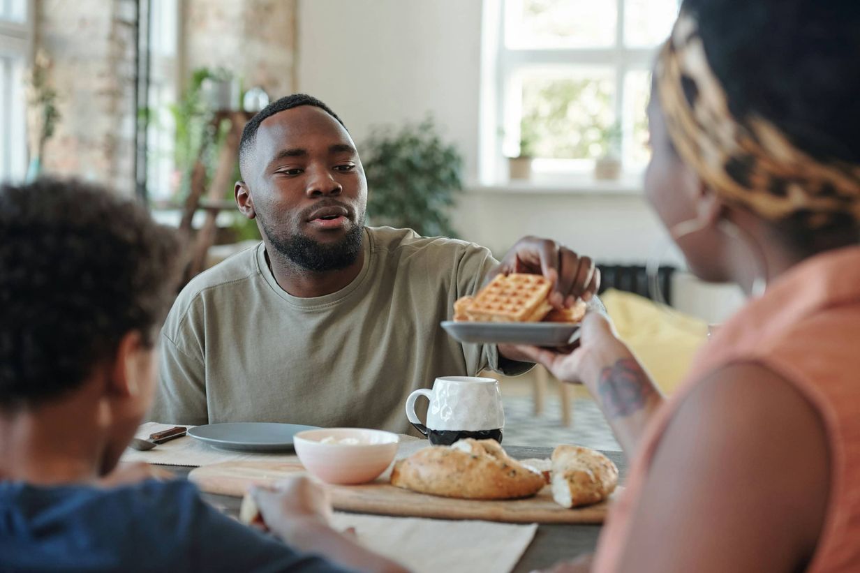 Young family eating breakfast together.
